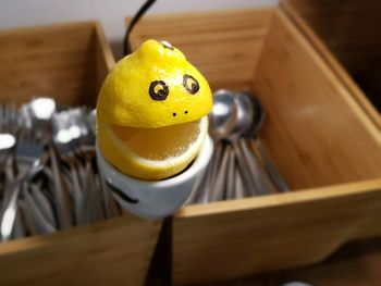 High angle view of smiley face lemon on cup