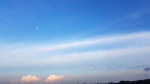 Low angle view of moon against blue sky