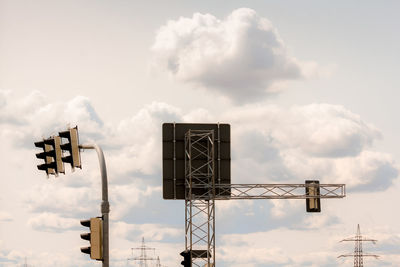 Low angle view of arrow sign against sky