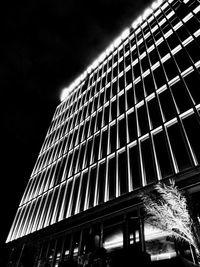 Low angle view of illuminated building against sky at night