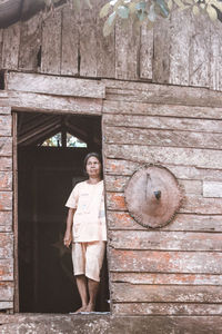 Portrait of girl standing against brick wall