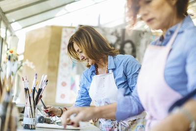 Cheerful women drawing in art workshop