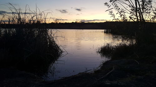 Scenic view of lake against sky at sunset