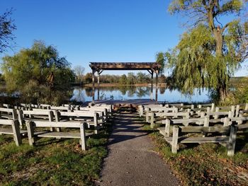 Empty bench in park against clear sky