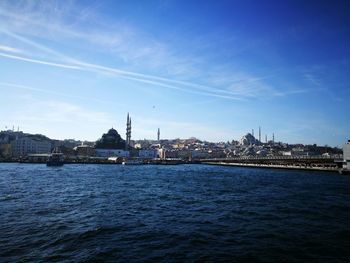 City at waterfront against blue sky