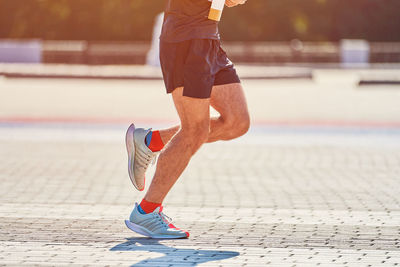 Running man. athletic man jogging in sportswear on city road. healthy lifestyle, fitness sport hobby