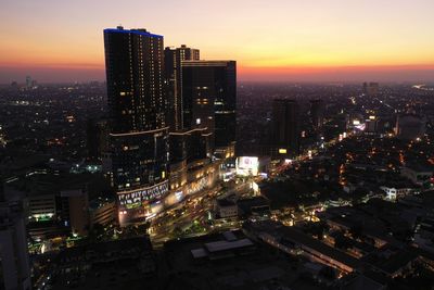 High angle view of illuminated buildings against sky at night