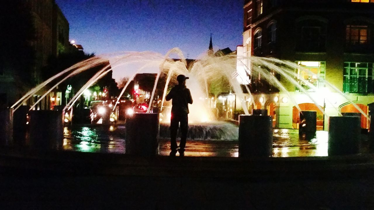 lifestyles, leisure activity, water, men, person, illuminated, full length, building exterior, built structure, architecture, silhouette, night, rear view, walking, city life, standing, motion, reflection