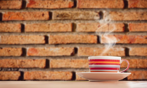 Close-up of coffee cup against wall