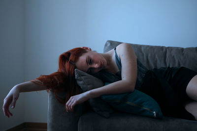 Young woman lying on sofa at home