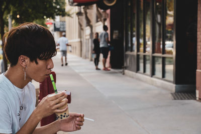 Side view of a man drinking glass