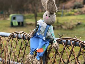 Close-up of scarecrow on fence at field