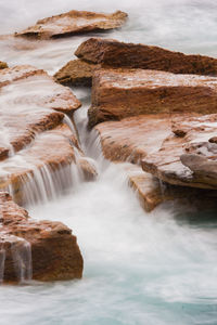 Scenic view of rocks in sea against sky