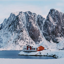 Snow covered houses and mountain against sky