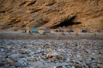 Tents on field against rocky mountains