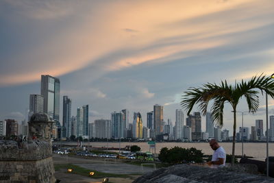 View of cityscape against cloudy sky