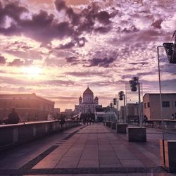 View of buildings against cloudy sky at sunset