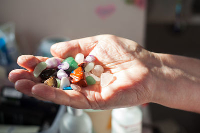 Cropped hands of senior man holding colorful stones