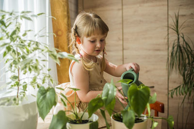 Girl watering plants at home