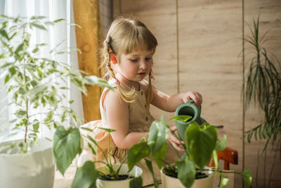 Cute girl looking away while potted plants