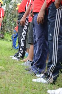 Low section of people standing on grass