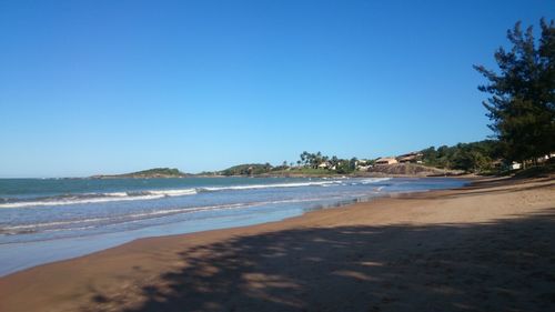 Scenic view of beach against clear blue sky