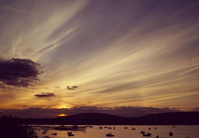 Silhouette people on beach against sky during sunset
