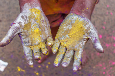 Low section of man with powder paint on hands during holi
