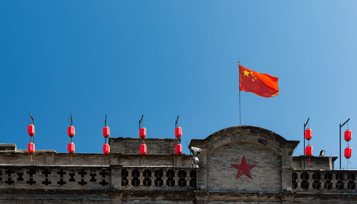 Low angle view of flag against clear blue sky