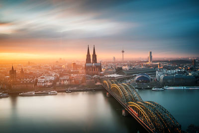 Bridge over river in city against sky