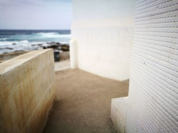 Close-up of stone wall by sea against sky