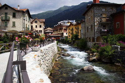 River flowing amidst buildings against mountains
