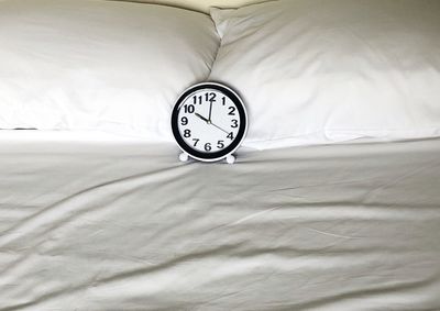 High angle view of clock on bed