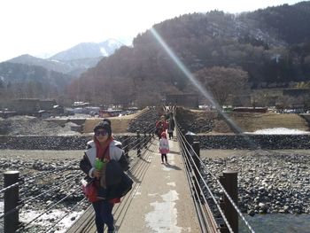 People on shore against mountains