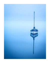 Sailboat in sea against blue sky