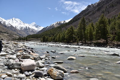 Scenic view of lake by snowcapped mountains against sky