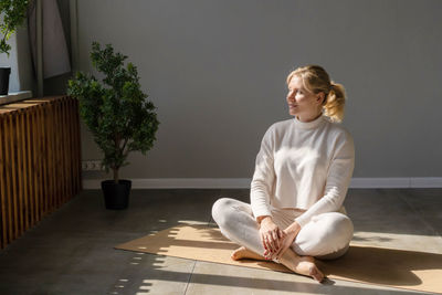 Young woman sitting on floor