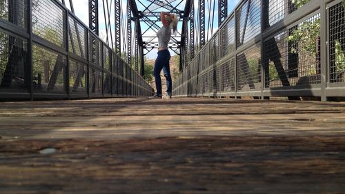 Side view full length of woman standing on footbridge