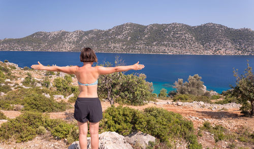 Rear view of woman standing on shore