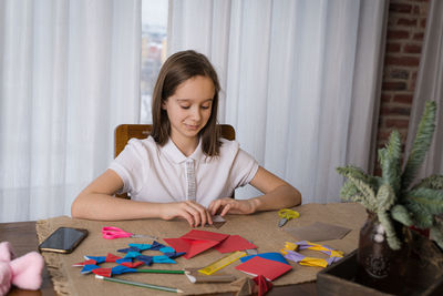 A beautiful teenage girl makes origami