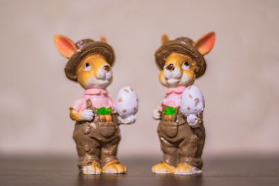 Close-up of figurines on table against colored background