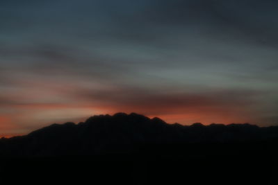 Scenic view of silhouette mountains against sky at sunset