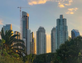 Skyscrapers in city against cloudy sky