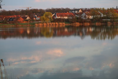 Scenic view of lake by buildings against sky