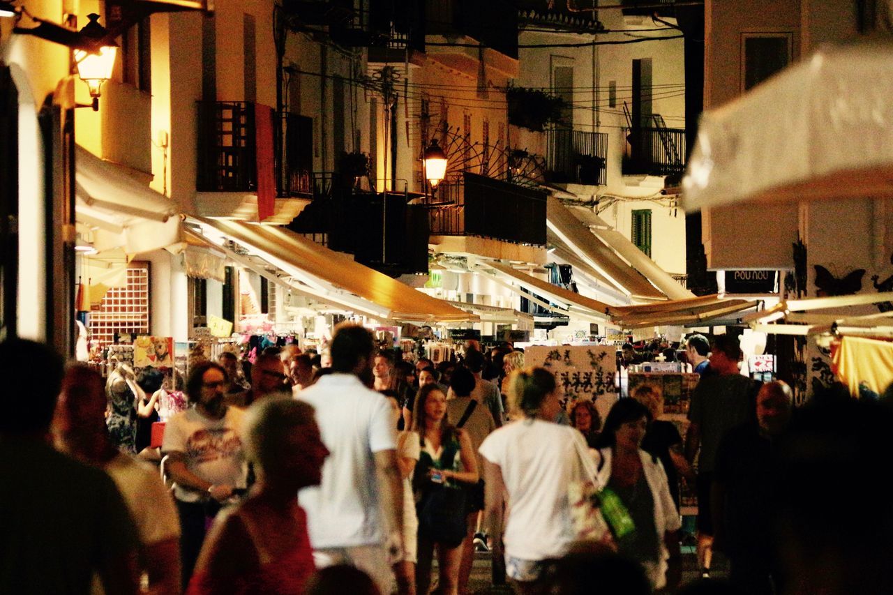 GROUP OF PEOPLE IN MARKET AT NIGHT