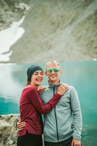 Portrait of friends standing against water