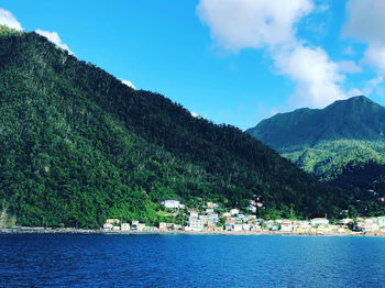 Scenic view of sea by mountains against sky