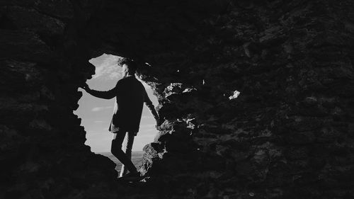 Low angle view of silhouette man standing on rock