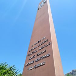 Low angle view of text on building against clear blue sky