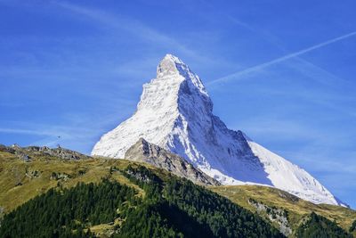 Low angle view of snow covered mountains against sky